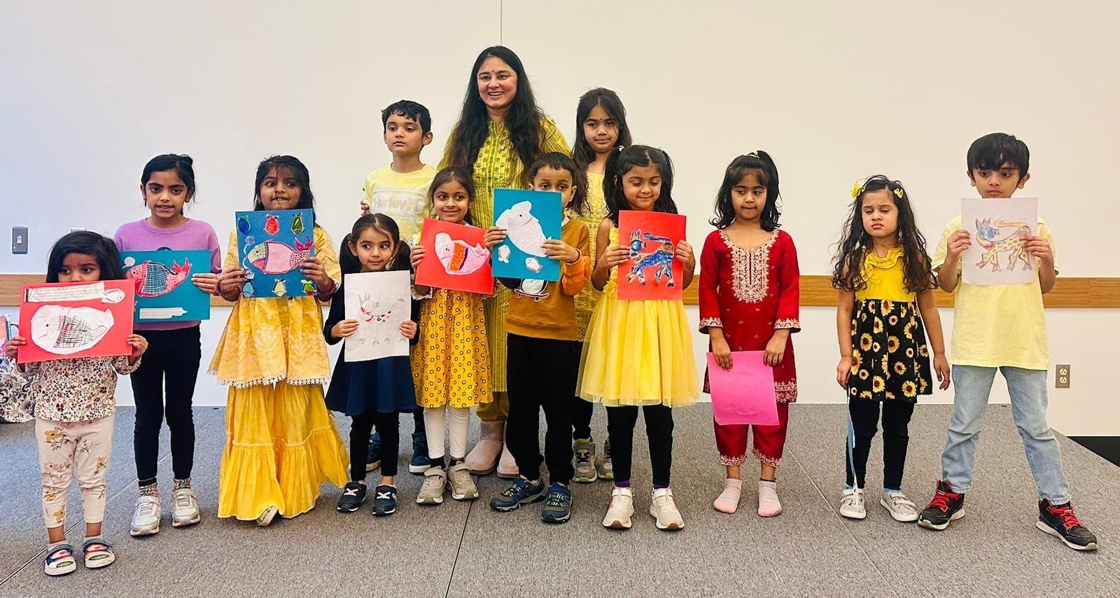 Children proudly holding up their artwork after an AKS craft session