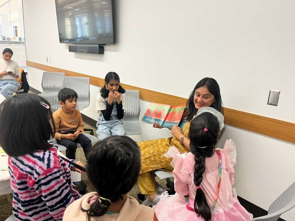 Divvya Singh reading to children seated in a circle at the library